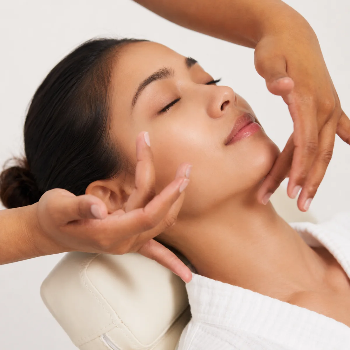 H&auml;nde f&uuml;hren eine Gesichtsmassage entlang der Kieferpartie durch